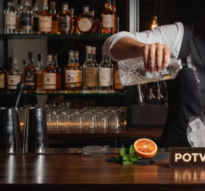 Barman w Di Piu MAGDALENA SIERAJ przygotowuje kolorowy autorski koktajl przy nowoczesnym barze
